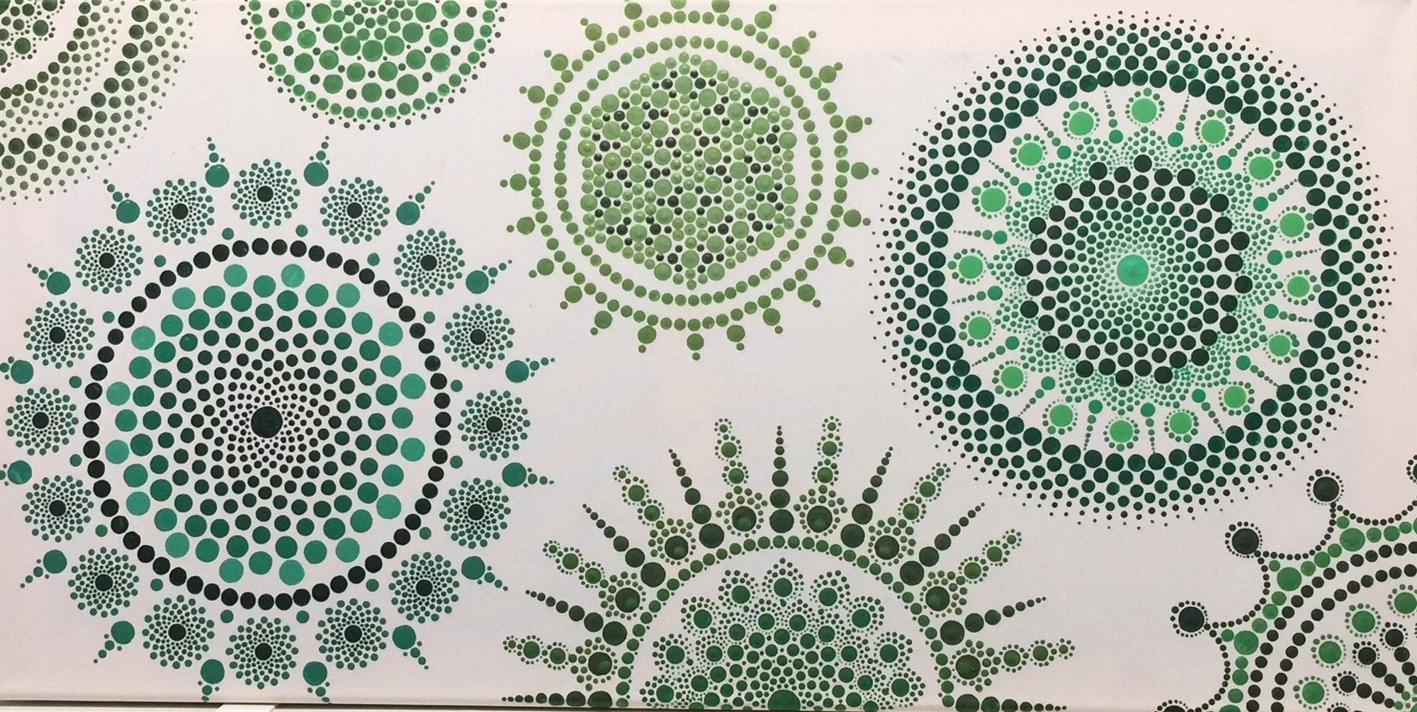 A large canvas of dot mandalas painted entirely in shades of green