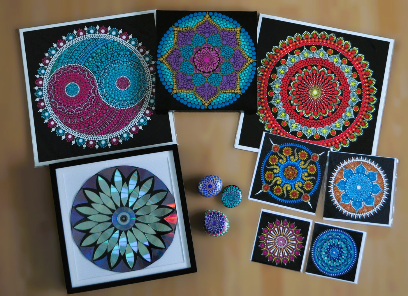 Sejal's greeting cards, prints, painted pebbles and a recycled DVD mandala laid out together